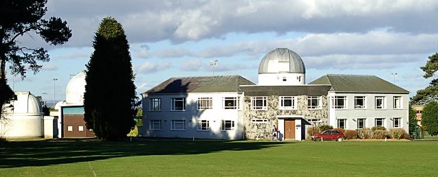 White observatory buildings, with three domes visible. 